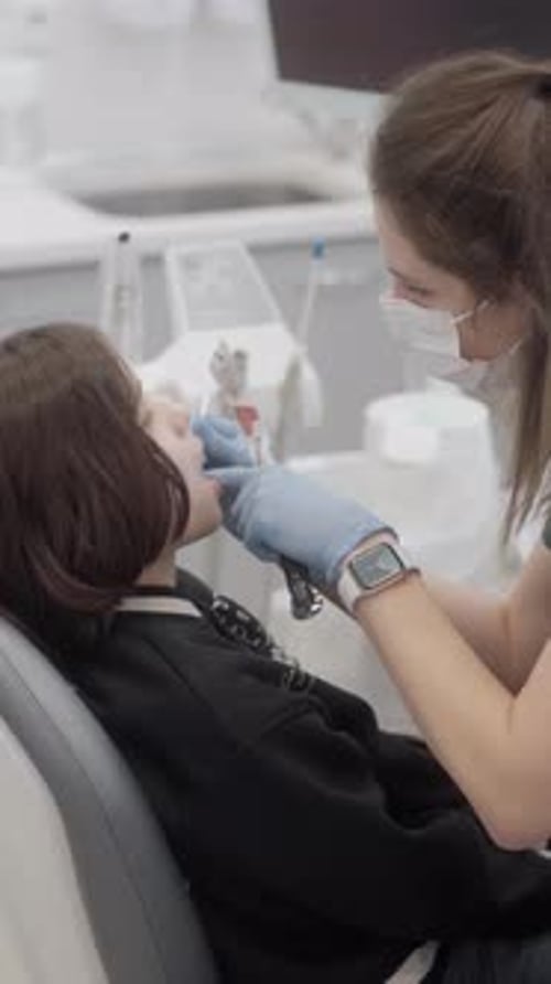 Dentist Examines Patient's Teeth in Modern Clinic