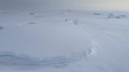 Tabular Iceberg Stuck in Frozen Ocean Aerial View