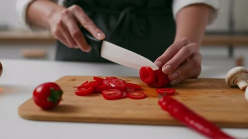 Woman Slicing Tomatoes in the Kitchen