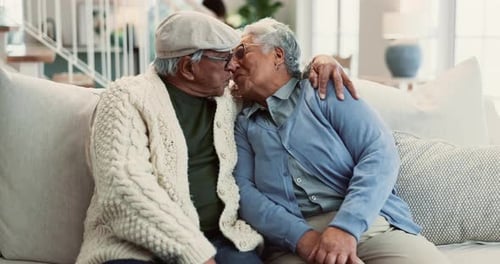 Affectionate Senior Couple Embracing on Couch at Home