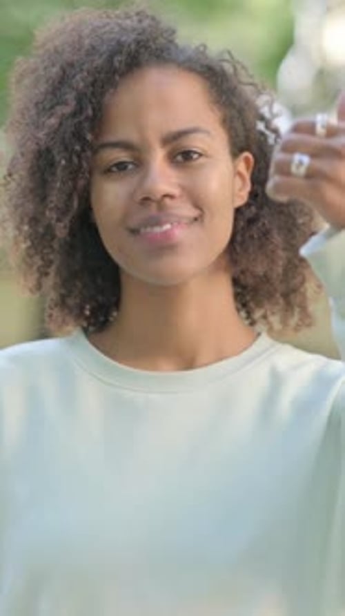 Smiling Woman Gives a Thumbs Up Outside