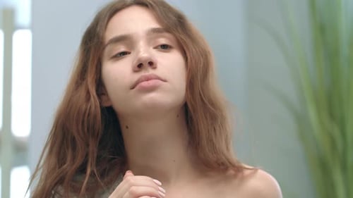 Young Woman Uses Nasal Spray in Bathroom