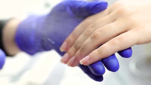 Manicurist Filing Customer's Nails at the Salon