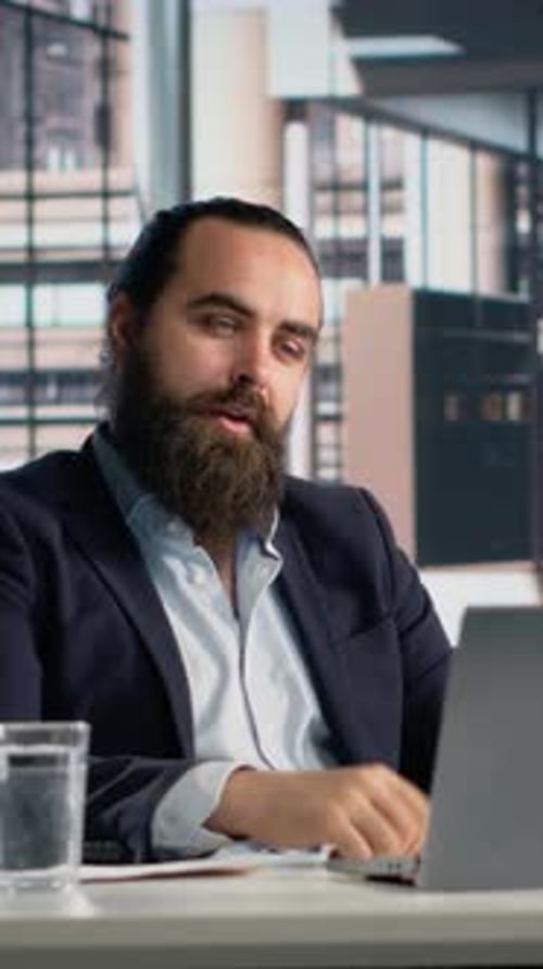 Man Video Conferencing in Modern Office Building