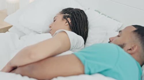 Couple Sleeping Peacefully Together in Bed at Home