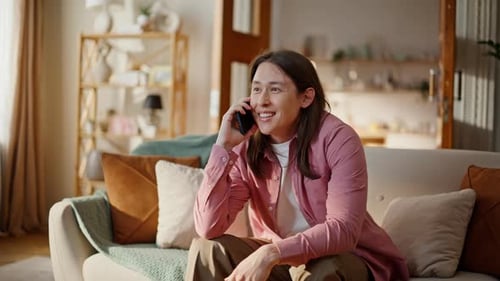 Smiling Man Relaxing on Sofa Talking on Phone