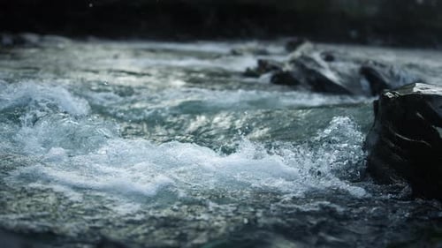 Mountain river flowing in slow motion at stone rapids in national park