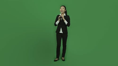 Attraktives asiatisches Mädchen in den Zwanzigern, isoliert auf einem chromagrünen Greenscreen-Hintergrund