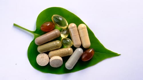 Pills and Capsules on a Green Leaf