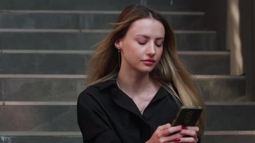 Woman Using Smartphone on Urban Steps