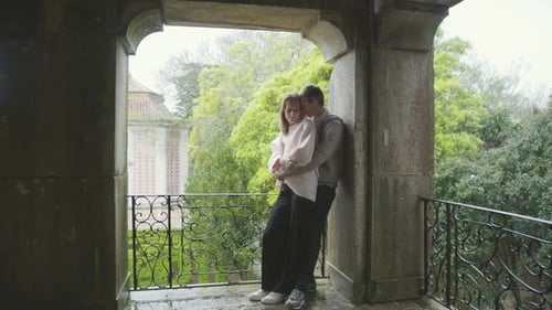 Romantic Couple Embracing on Balcony of Historic Building