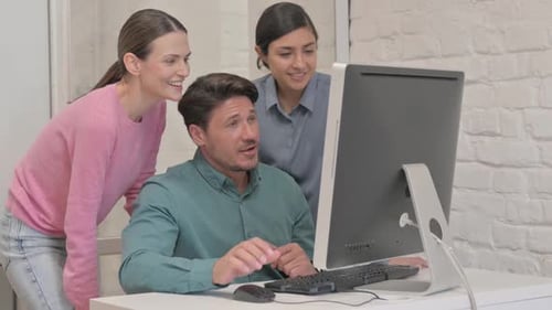 Collaborative Team Looking at Computer in Office