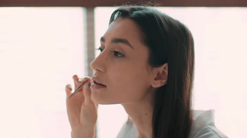 Woman Applying Makeup in a Bright Room With Natural Light in Slow Motion Footage Captured in