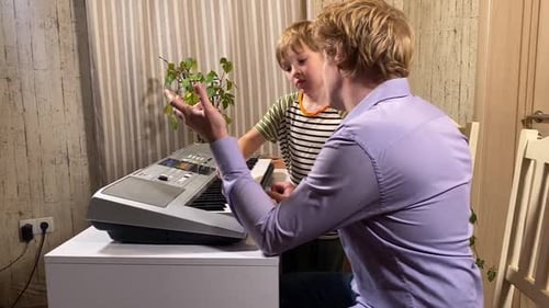 Man Teaches Young Boy How to Play Keyboard