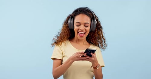 Dancing, cellphone and woman with headphones in studio typing