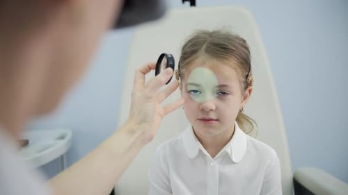 Doctor Examining Child Eye with Optical Lens