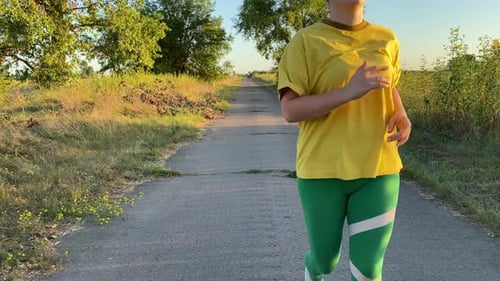 Woman Running on Rural Road in Countryside