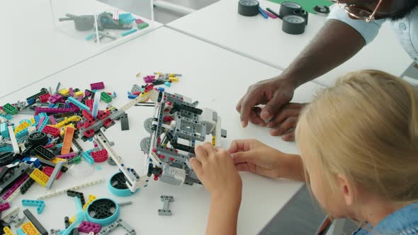 Girl Making Model Structure from Plastic Blocks and Teacher Helping ...