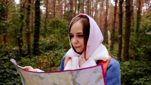 Cute Girl Reading Map in Forest