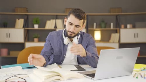 Focused Student Studies with Books and Laptop