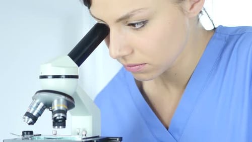 Ärztin mit Mikroskop im Labor für Forschung