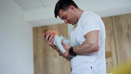 Loving Father Holding Newborn Infant in His Arms