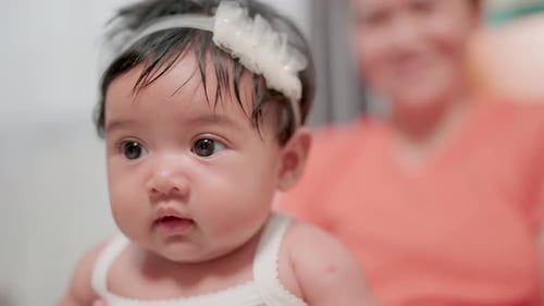 Cute Infant with Floral Headband Looking Curious