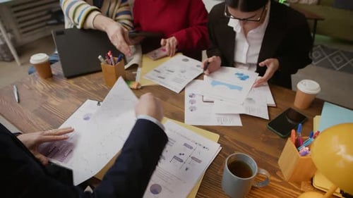 Team of Employees Meeting at Office Desk Analyzing Business Charts