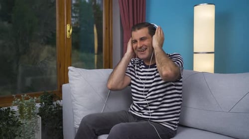 Man Listening to Music with Headphones on Couch