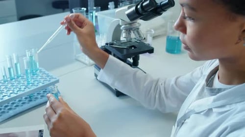 Scientist Using Pipette to Transfer Liquid into Test Tube