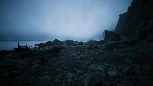 Dark Shoreline Littered with Weathered Wood and Scattered Metal Pieces
