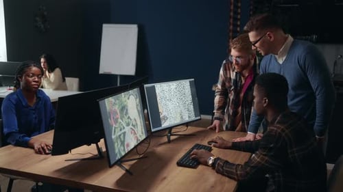 Team Working Together on Computers in a Workplace