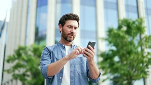Man Using Phone Reacts With Joyful Surprise