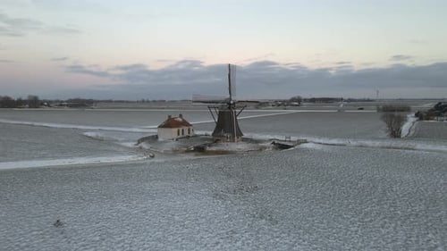Luftaufnahme der ikonischen alten Windmühle im Winter mit Schnee, Niederlande