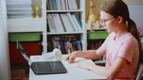 Young Student Doing Homework with Laptop at Desk