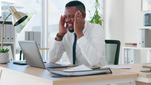Corporate black man, headache and stress at office desk with burnout, depressed or overworked
