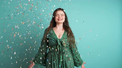 Woman Enjoys Confetti Shower Against Blue Background