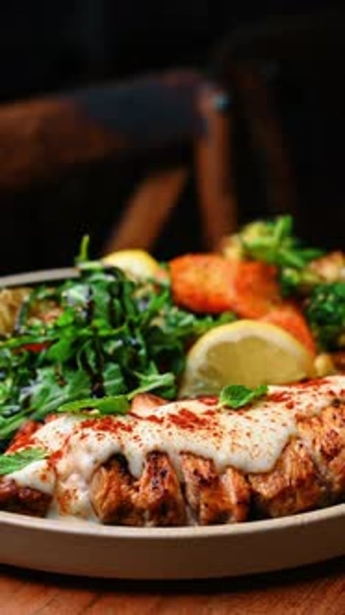 Close up of grilled salmon fillet with white sauce garnish.