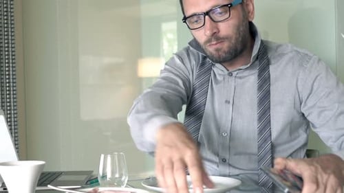 Man Working at Breakfast Table