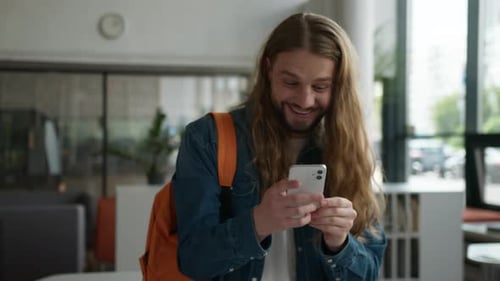 Excited Man Celebrates Success on Phone in Modern Office