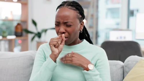 Woman Coughing Due to Illness While Sitting at Home
