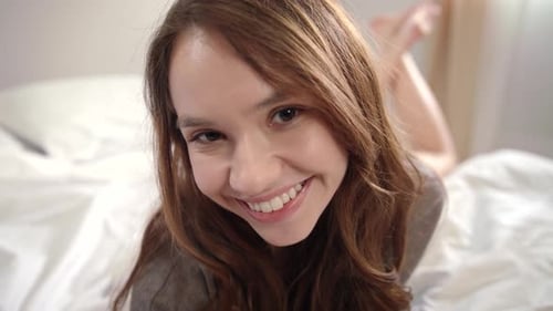 Young Woman Lying in Bed. Close Up of Sexy Woman Face Posing