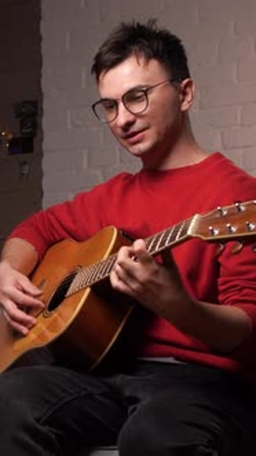 Man Playing Guitar in a Room