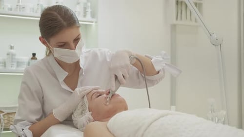 Woman Receiving Facial Treatment in Bright Medical Clinic