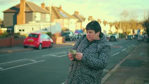 Woman Standing on Sidewalk Counting Dollars Old Female on Street Examining Dollar Bills