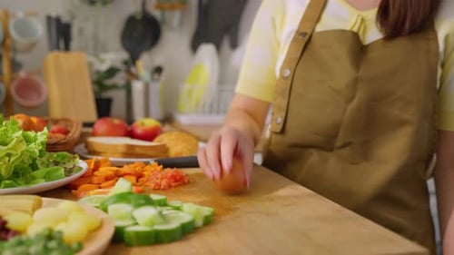 Close up of woman cooking healthy foods in kitchen in morning at home.