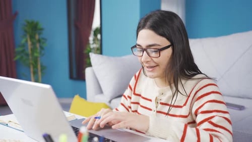 Woman Works on Laptop at Home Desk