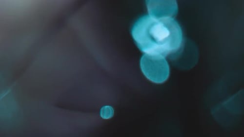 Abstract Cyan Light Flares and Black Backdrop
