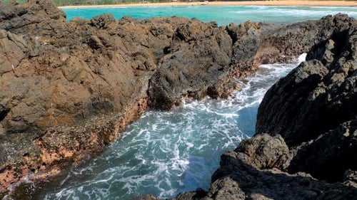 Waves Beat Against Big Rocks in the Ocean with Clear Water Concept of Nature