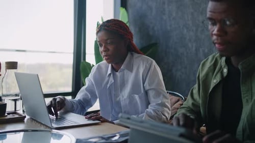 Sitting Next to a Laptop at a Cafe Two Black Business Partners a Male and a Female Exchange Ideas
